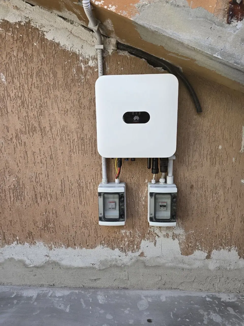 Inverter fotovoltaico a parete con i quadri di sezionamento sottostanti