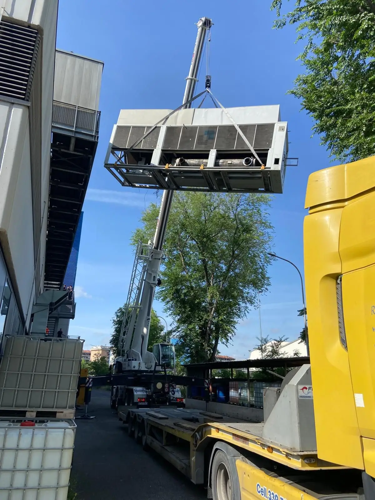 Sollevamento del gruppo frigorifero con carrello elevatore a fianco dell’edificio
