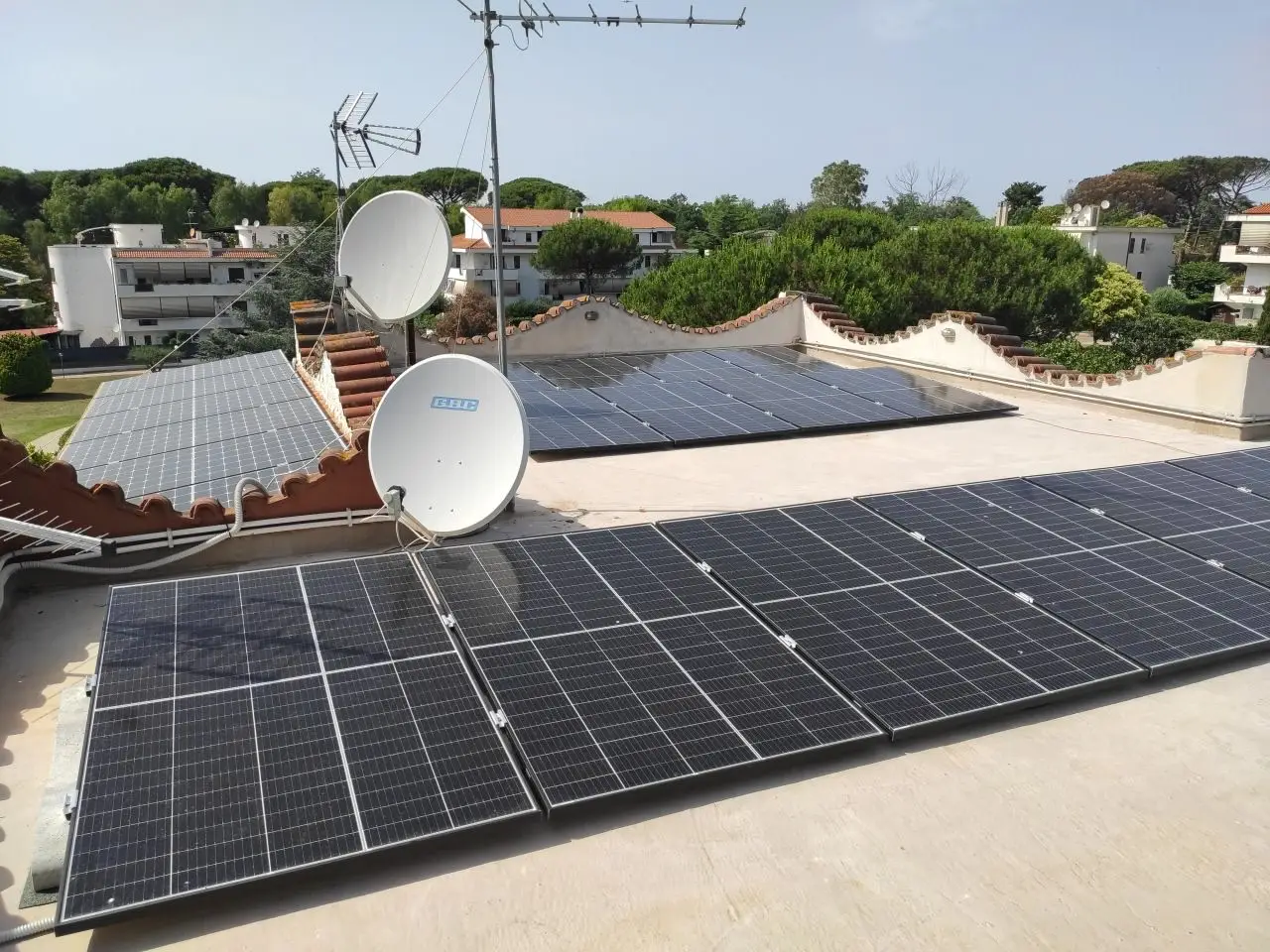 Moduli fotovoltaici e parabola satellitare sulla copertura dell’edificio