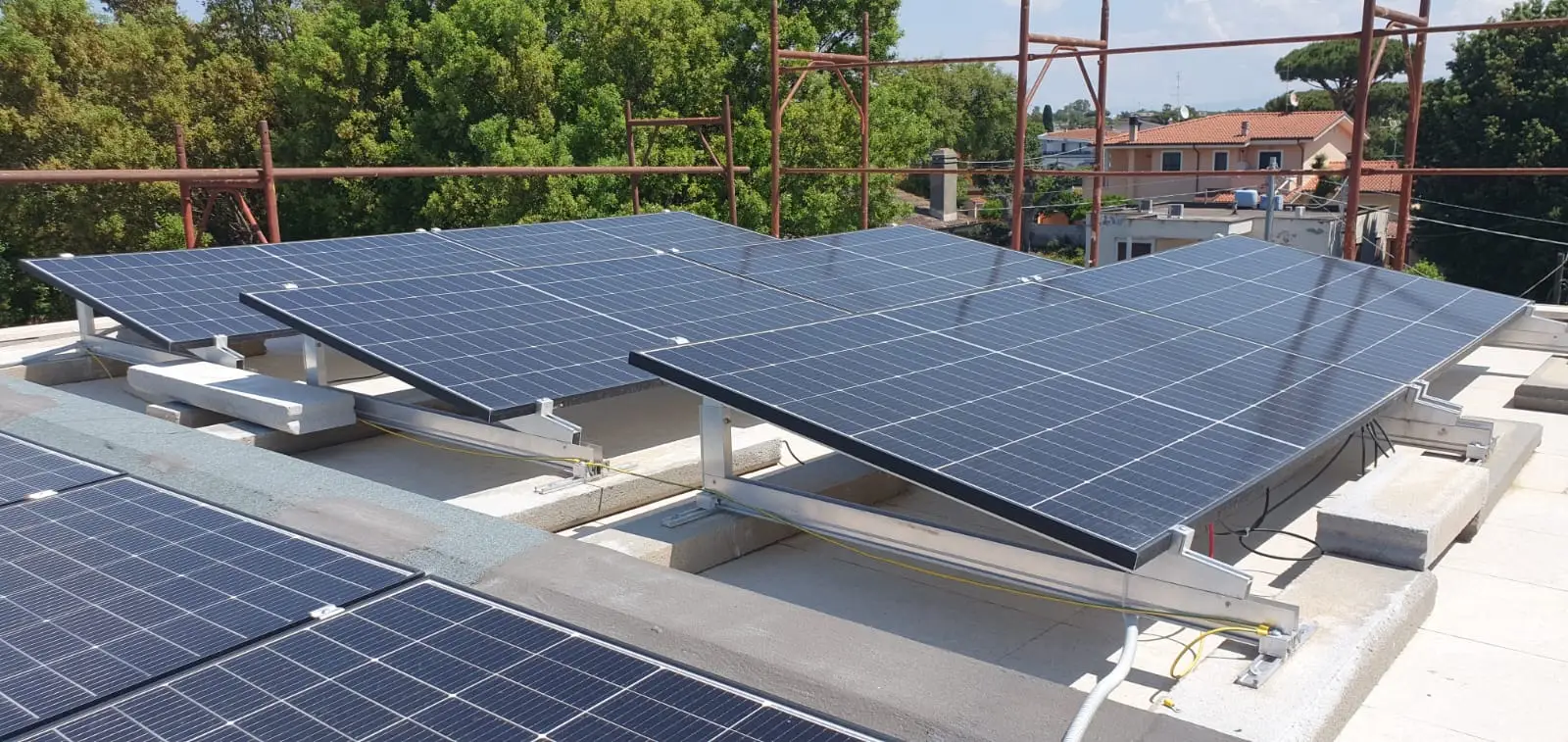 File di moduli fotovoltaici su strutture inclinate in copertura