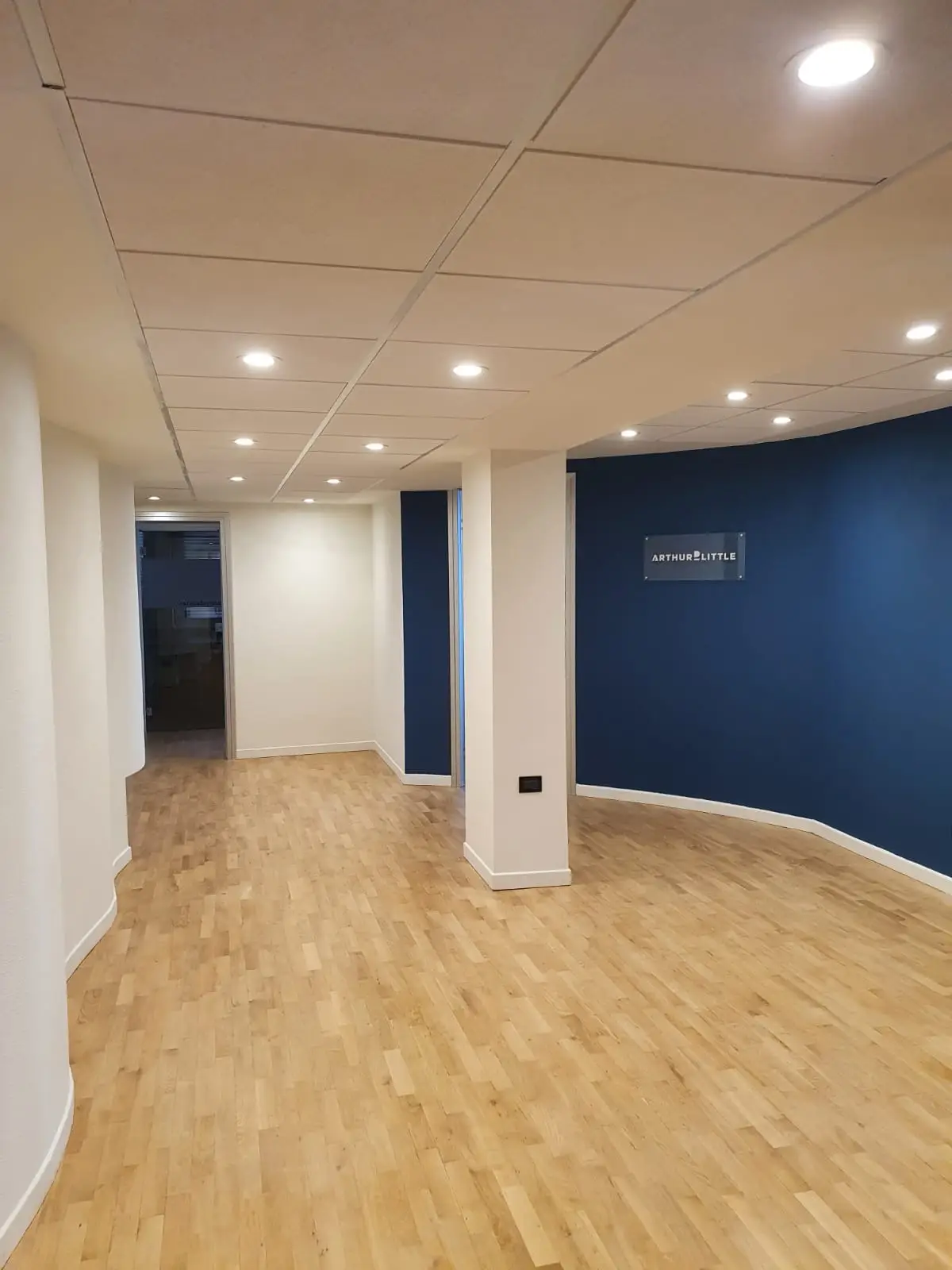 Corridoio degli uffici con pavimento in legno e illuminazione a incasso