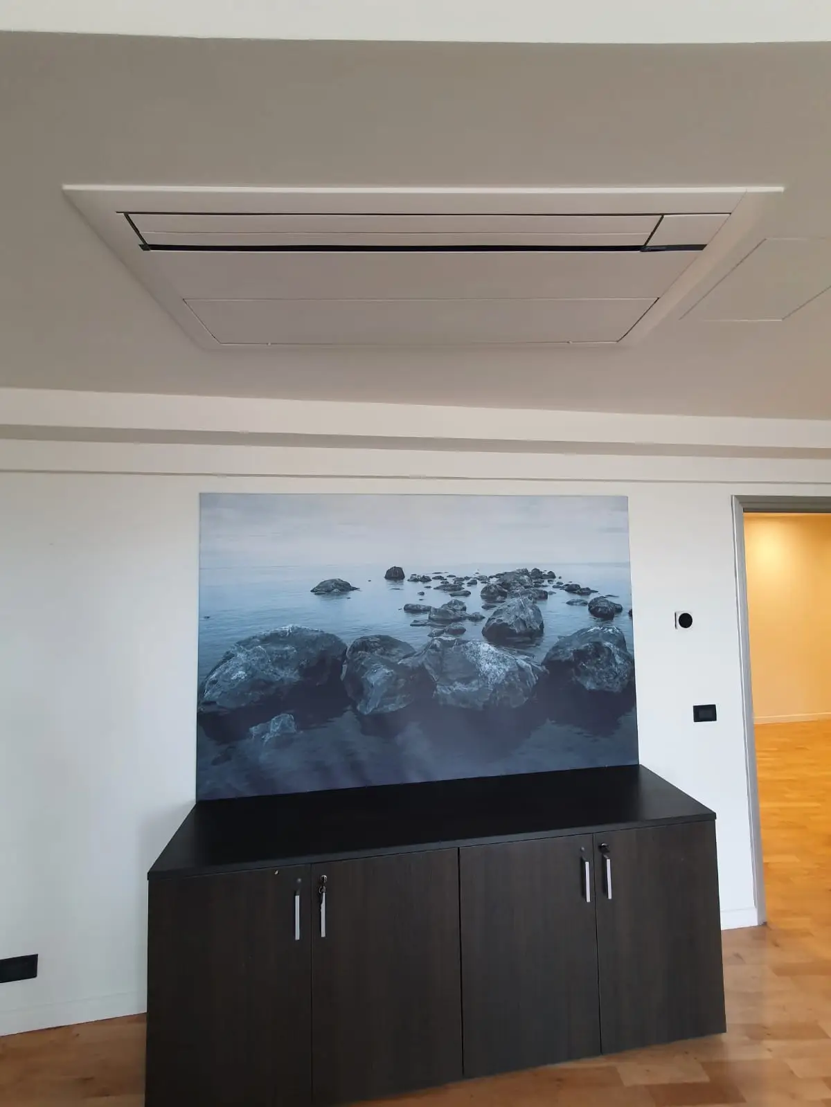 Sala riunioni con unità a cassetta a soffitto e arredi su misura