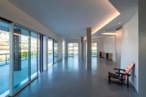 Vista d’insieme della zona giorno con vetrate continue e diffusori a soffitto